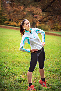 Full length of woman with hands on hip exercising in park