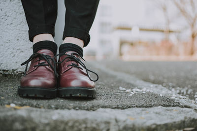 Low section of woman standing on road