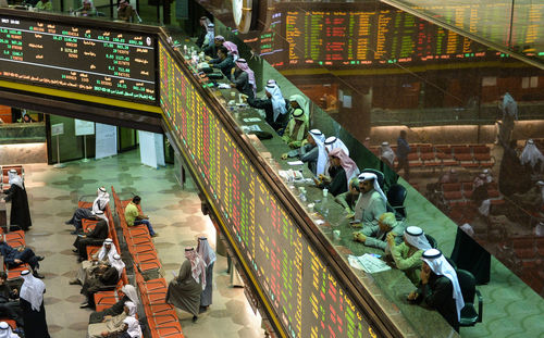 Traders monitor stock prices in the stock market in kuwait