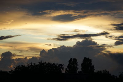 Silhouette of trees against cloudy sky