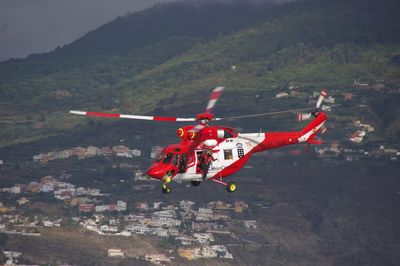 High angle view of airplane flying over mountain against sky