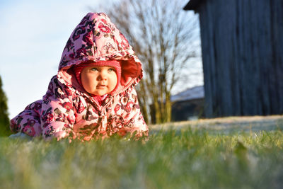 Portrait of cute baby girl on field