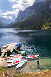 Boats moored on lake against mountains