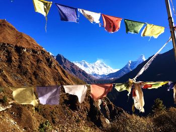 Low angle view of flags against mountain range