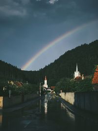 Scenic view of rainbow against sky during rainy season