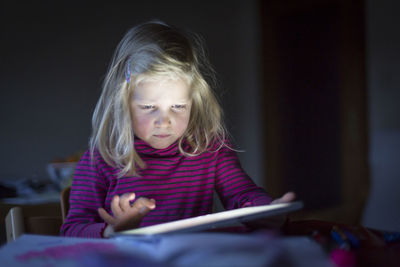 Girl using digital tablet on desk at home