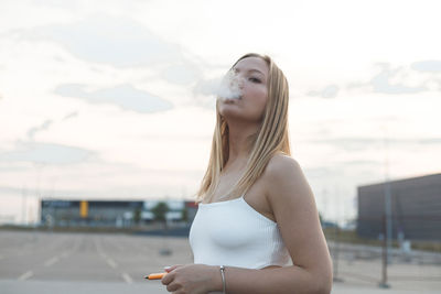 Woman looking at camera against sky