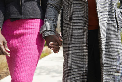 Couple holding hands while walking on sunny day