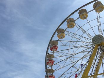 Low angle view of ferris wheel against blue sky