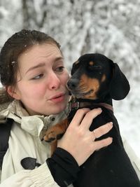 Close-up of woman with dog in snow