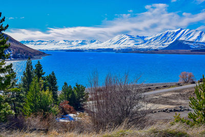 Scenic view of lake by mountains against sky