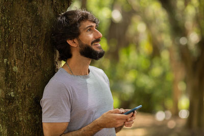 Young man at park on a beautiful sunny day with mobile phone.  working  leisure. green and nature 