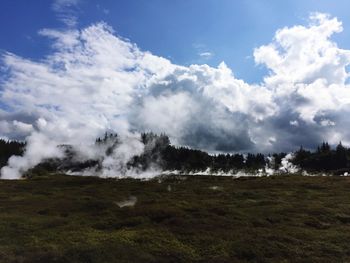 Scenic view of grassy landscape against cloudy sky