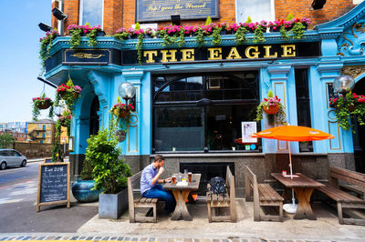 Woman sitting at restaurant against building