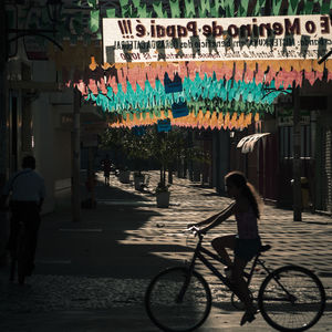 People riding bicycle on street in city