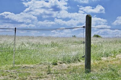 Fence on field against sky