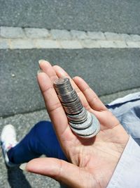 Low section of woman showing coins on road