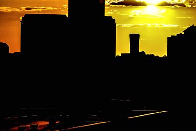 Silhouette city against sky during sunset