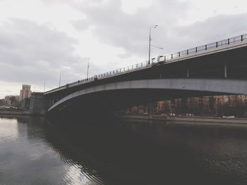 Bridge over river against sky in city