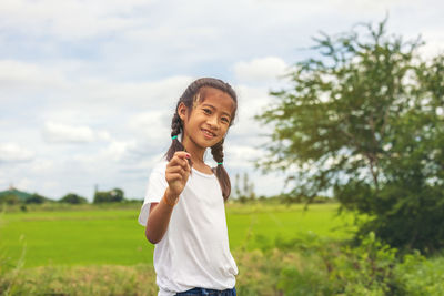 Portrait of smiling girl standing on field