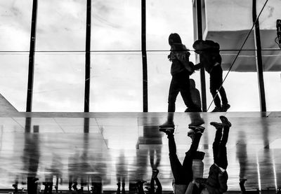 Upside down image of people walking on floor at airport