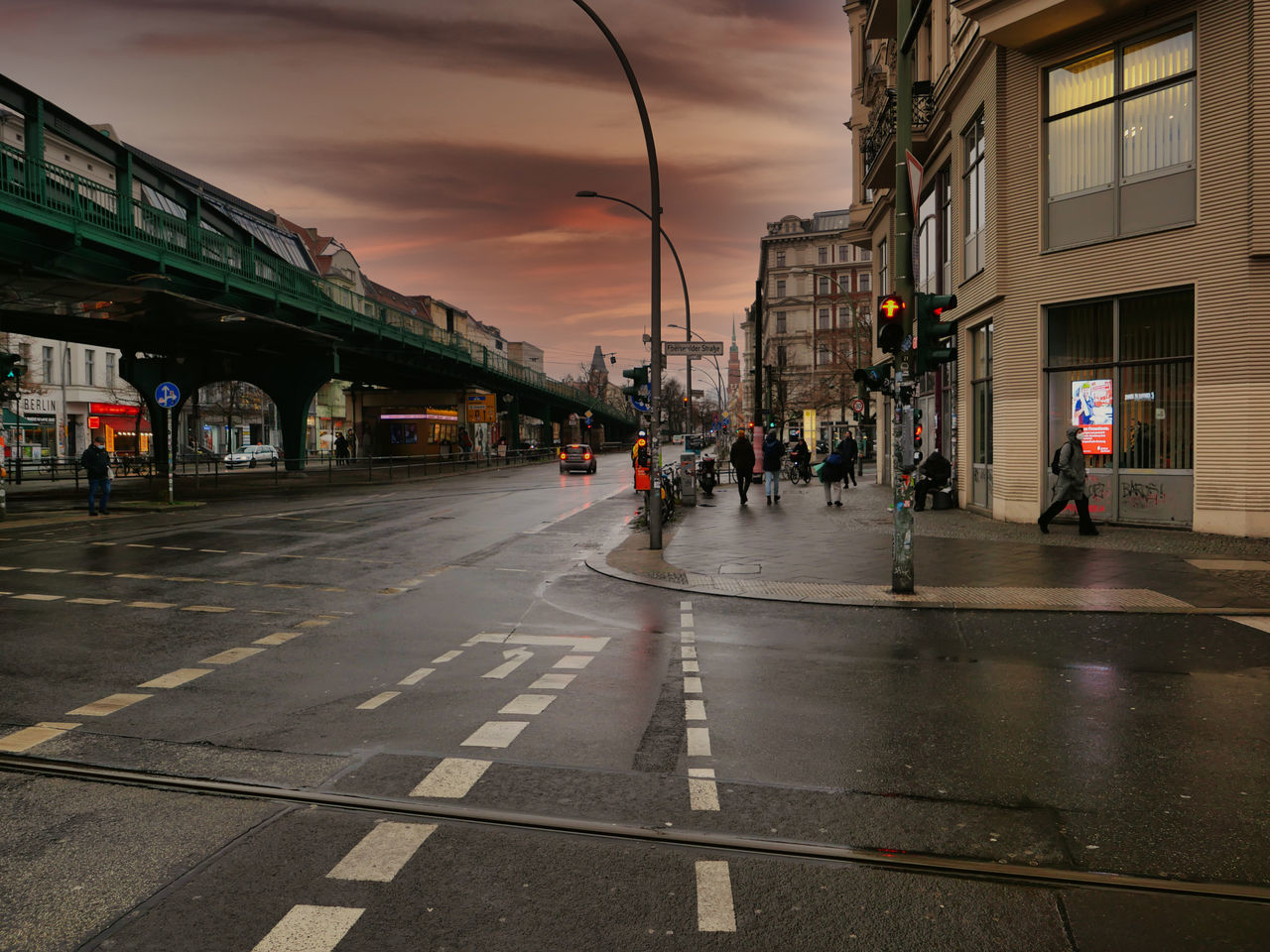 PEOPLE WALKING ON WET STREET IN CITY