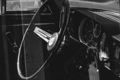 Steering wheel of vintage car seen from window glass