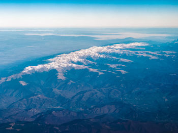 Aerial view of snowcapped mountains against sky