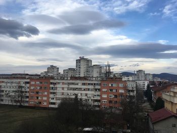 Low angle view of buildings against cloudy sky