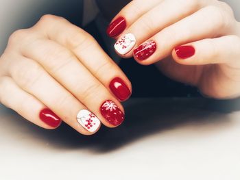 Close-up of woman wearing red nail polish on fingernails