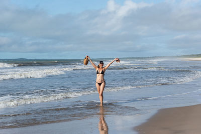 Full length of woman standing at beach