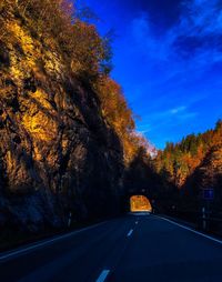 Road amidst trees against sky