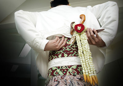 Rear view of man holding umbrella standing at home