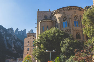 Low angle view of buildings against clear sky at santa maria de montserrat abbey