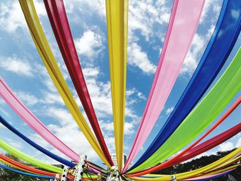 Low angle view multi colored textile decoration against sky