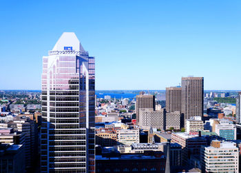 Modern buildings in city against clear blue sky