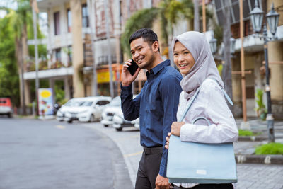 Side view of young woman standing in city