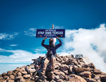 Information sign on rock against sky