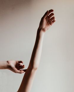 Midsection of woman holding hands against white background