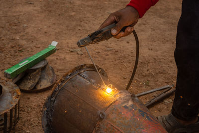 Low section of man working on metal