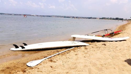 Boat moored on beach against sky