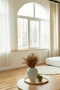 Vase with flowers on table in room