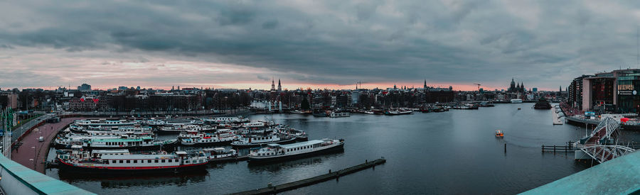 High angle view of river amidst buildings against sky during sunset