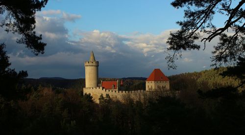 Castle on field against cloudy sky