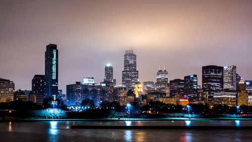 Illuminated buildings against sky at night