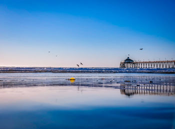 Pier over sea against blue sky