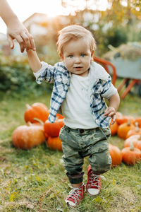 A happy baby is holding hands with his mother during the preparation for the halloween holiday