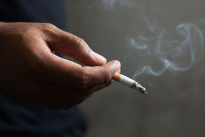 Cropped hand of person holding cigarette