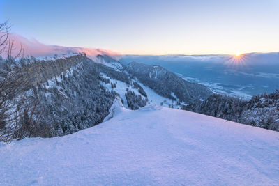 Scenic view of snowcapped mountains against sky during sunset