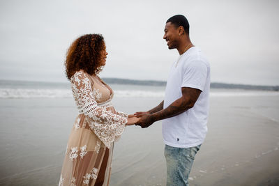 Mixed race couple holding hands on beach